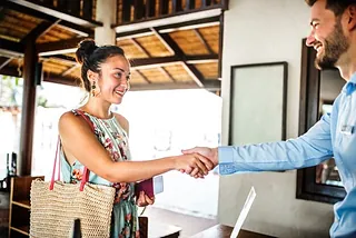 Pareja de personas mayores caminando por areas verdes con esterillas de yoga